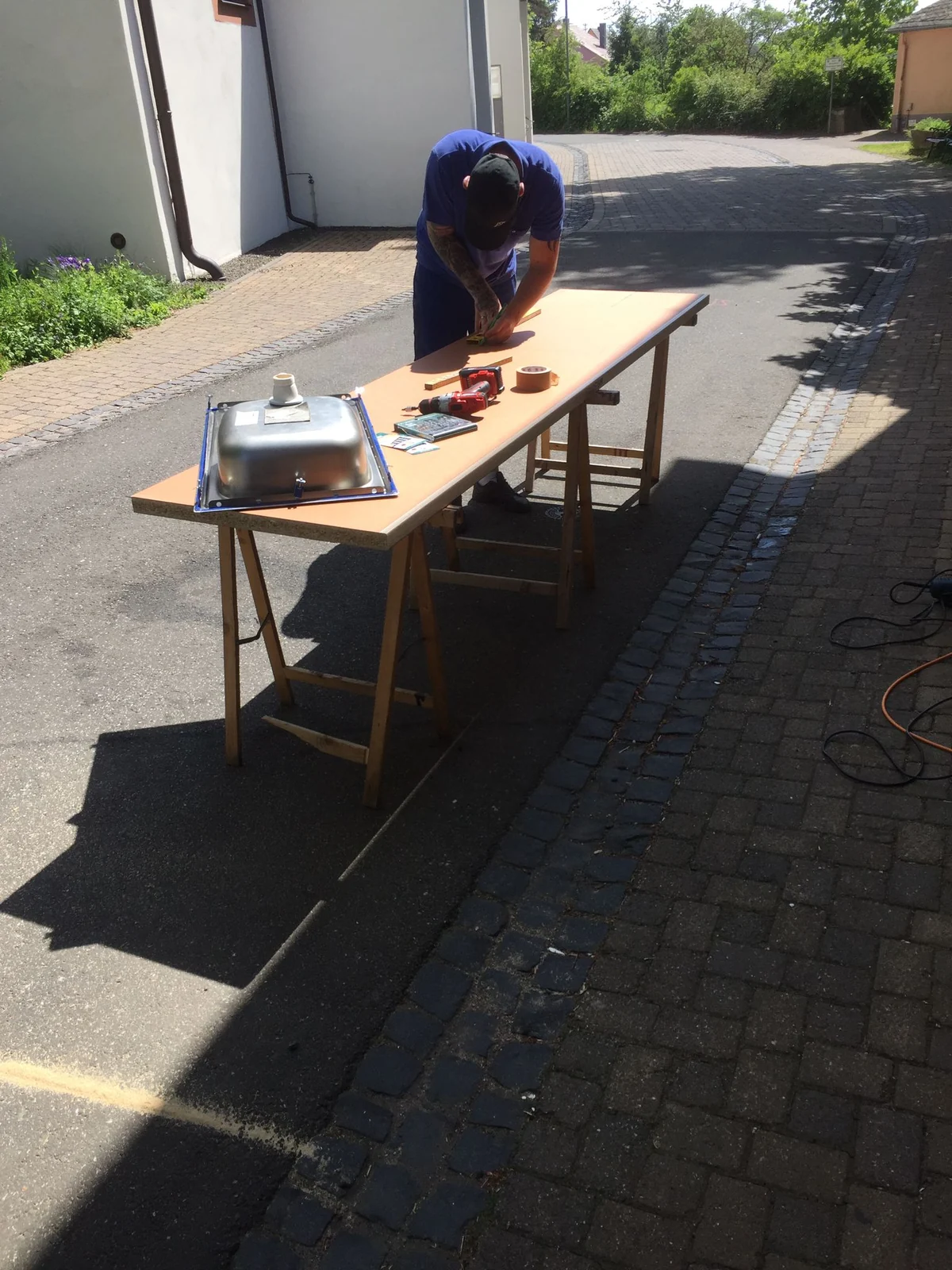 Monteur beim Vorbereiten einer Arbeitsplatte auf Arbeitsböcken im Freien
